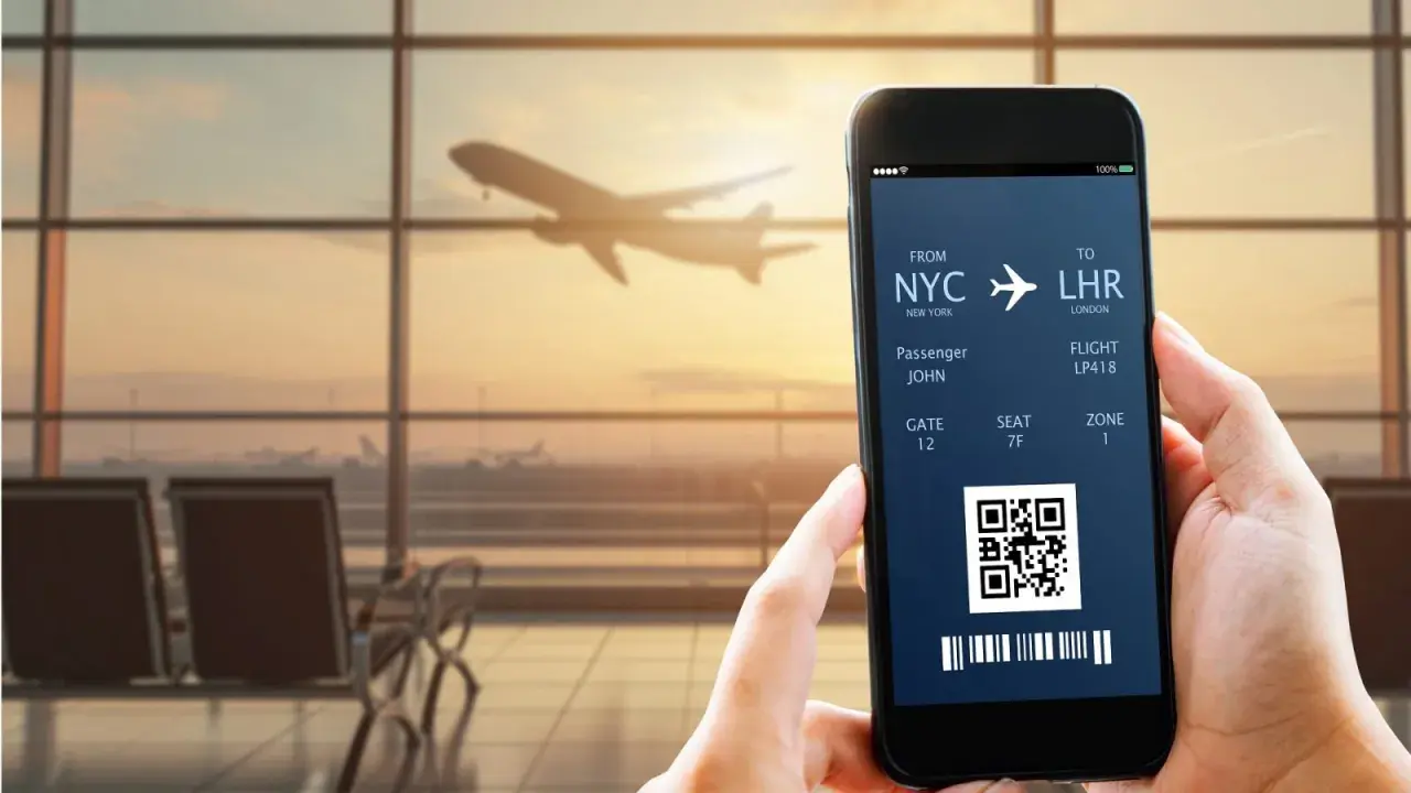 Bilet lotniczy na telefonie: NYC do LHR, pasażer John, lot LP418. IATA co to? To kod lotniska.