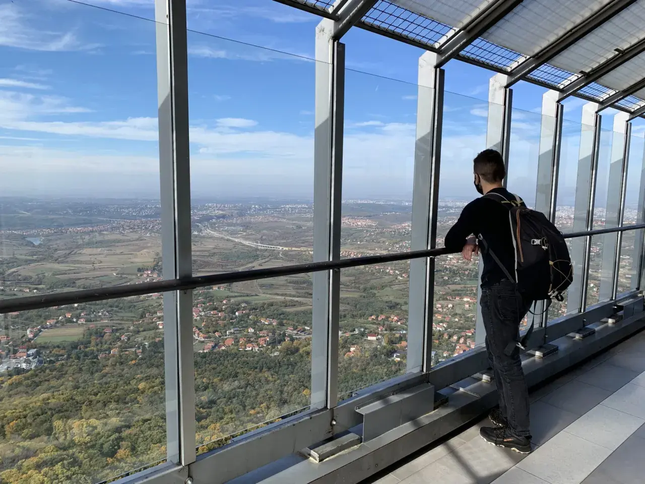 Widok z wieży na Belgrad, stolicę Serbii. Mężczyzna z plecakiem podziwia panoramę miasta i okolic.