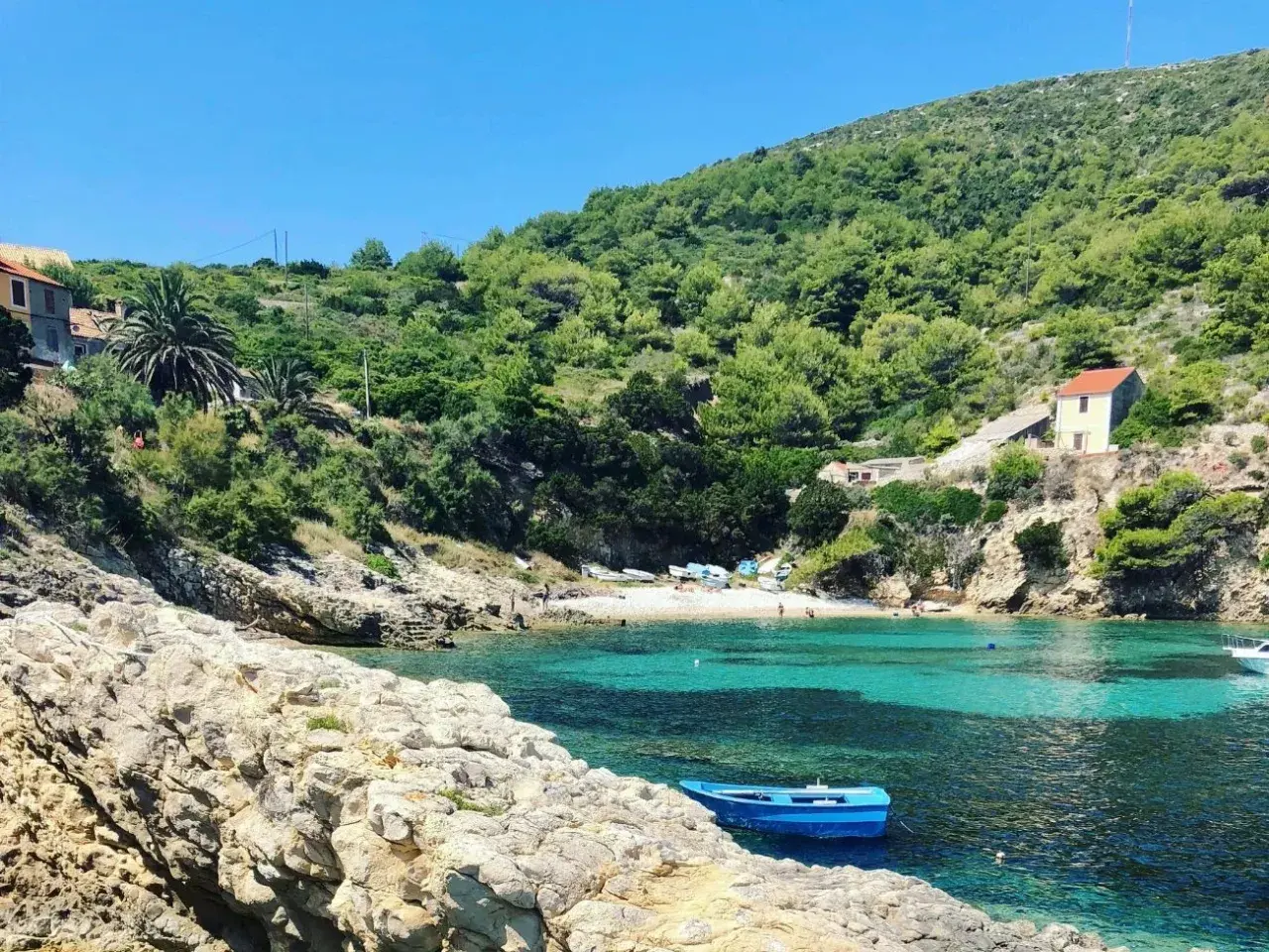 Ukryta zatoczka z turkusową wodą, kamienistą plażą i domkami na wzgórzu. Idealne miejsce na odkrycie mało znanych miejsc w Chorwacji.