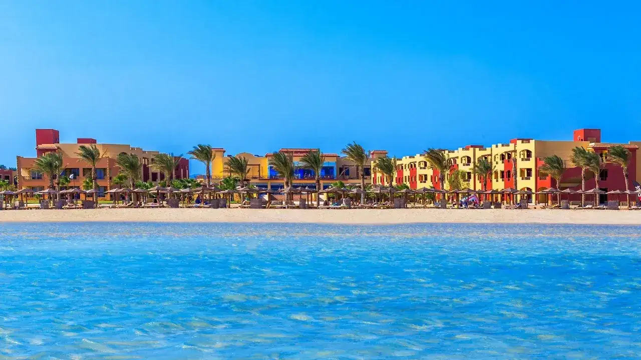 Piękna plaża i kolorowe budynki Casa Mare Resort (dawniej Royal Tulip Beach Resort) pod błękitnym niebem.