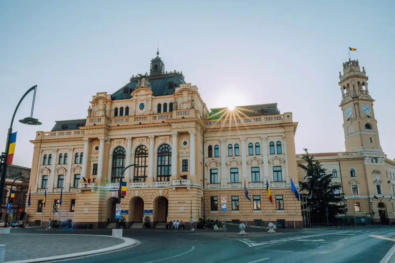 Majestatyczny ratusz i wieża zegarowa w Oradea, Rumunia, lśnią w słońcu.