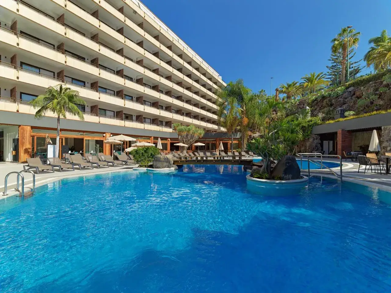 Basen hotelu Fergus Puerto de la Cruz z leżakami i palmami.