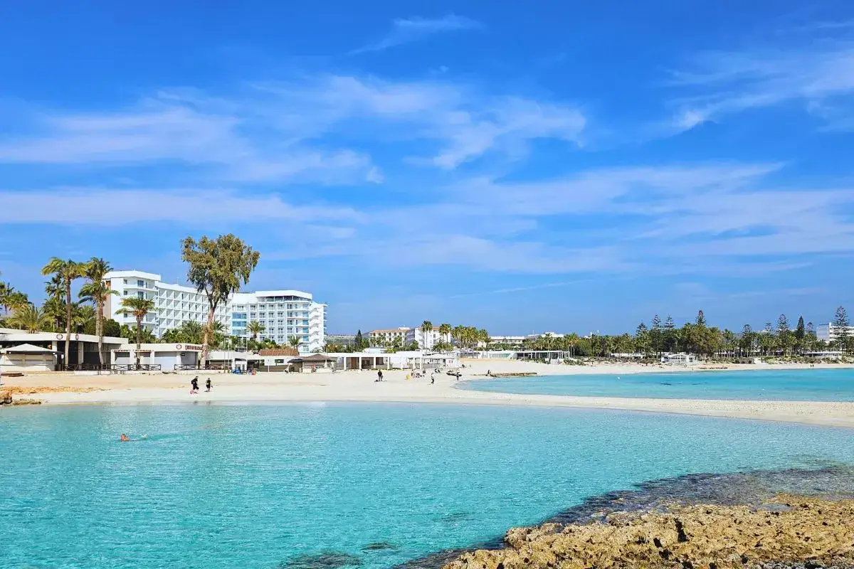 Piękna plaża z białym piaskiem i turkusową wodą, hotele i palmy. Ayia Napa atrakcje w pełnej krasie.