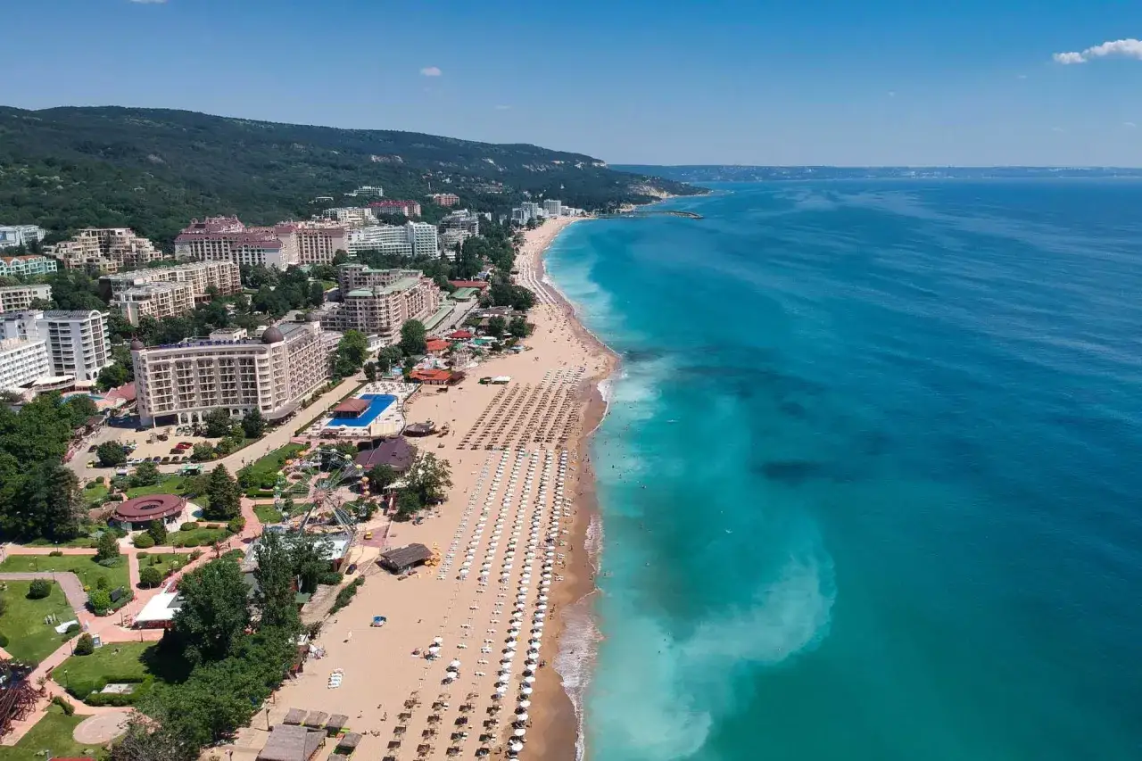 Bułgaria, Złote Piaski: widok z lotu ptaka na szeroką plażę z rzędami leżaków, hotele i park rozrywki. Idealne miejsce na wakacje!