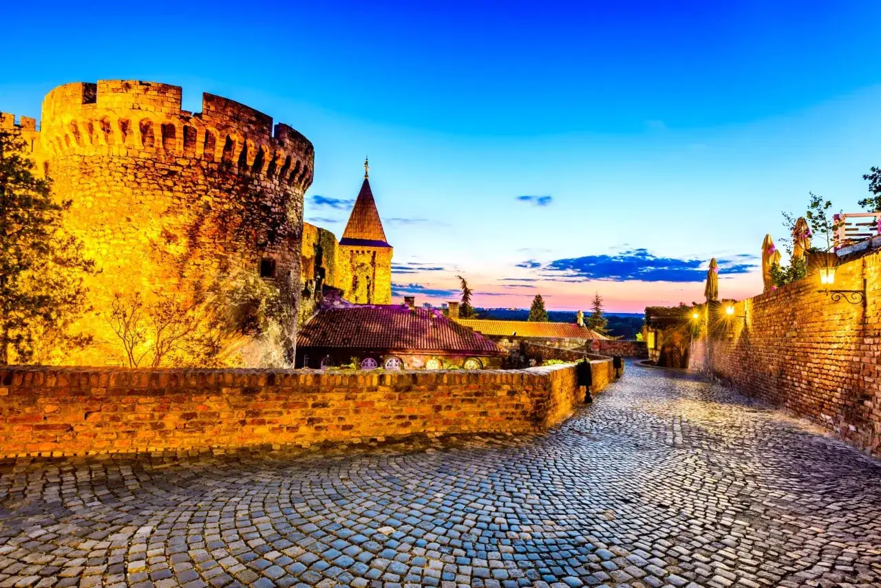 Twierdza Kalemegdan w Belgradzie, idealne miejsce, by zobaczyć, co Serbia ma do zaoferowania. Brukowana ścieżka prowadzi przez zabytkowe mury o zachodzie słońca.