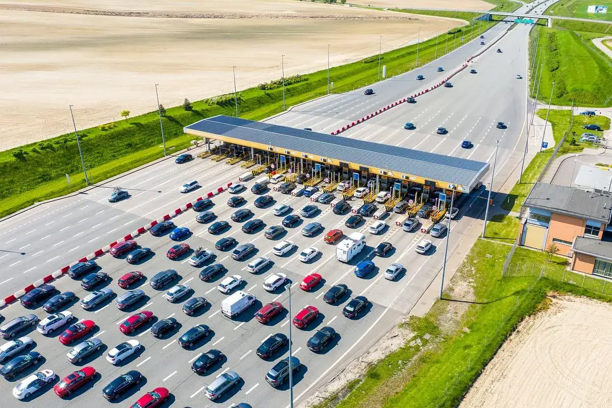Korki na autostradzie. Długie kolejki samochod&oacute;w czekają, by zapłacić za przejazd.