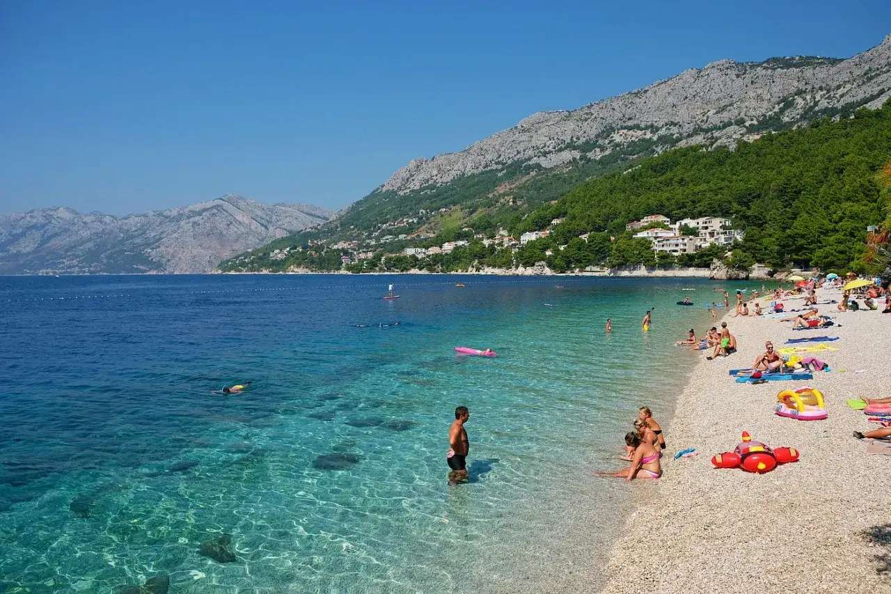 Idealne wakacje w Chorwacji z dziećmi: piaszczysta plaża, krystalicznie czysta woda i góry w tle. Relaks i zabawa dla całej rodziny.