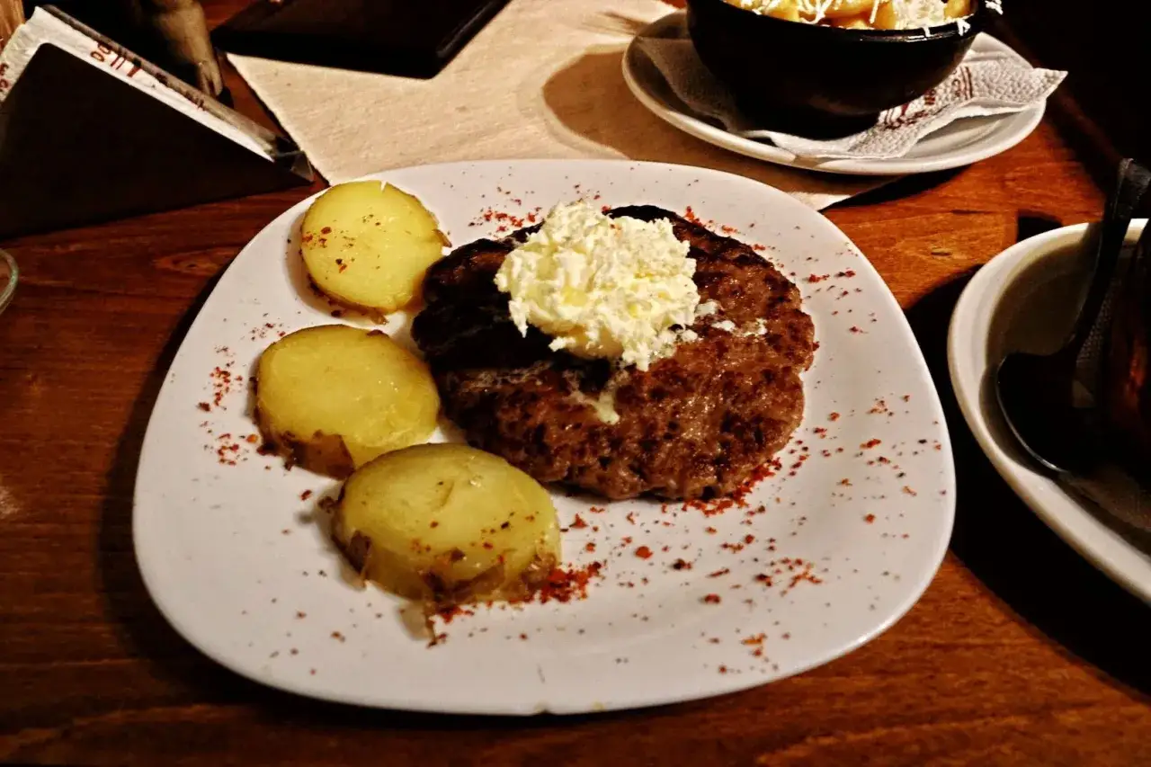 Macedonia jedzenie: soczysty kotlet mielony z masłem i ziemniakami, posypany papryką. Pyszny posiłek.