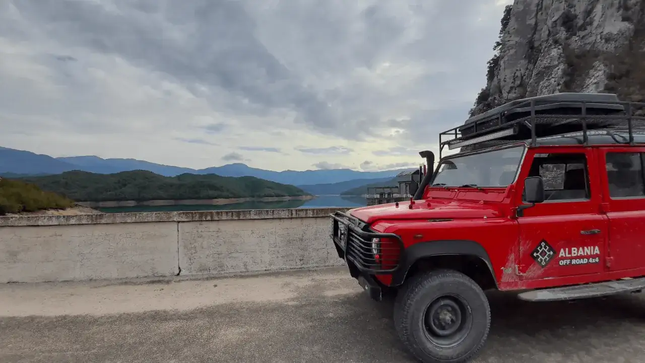 Czerwony Land Rover Defender z napisem 