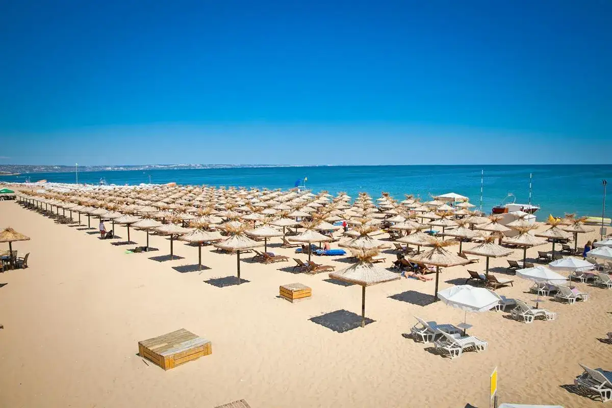 Słoneczna plaża w Bułgarii w sierpniu, pełna leżaków i parasoli. Idealna pogoda na wakacje.
