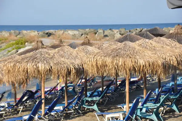 Słomiane parasole i leżaki na plaży, idealne na relaks. Riwiera Olimpijska atrakcje czekają!