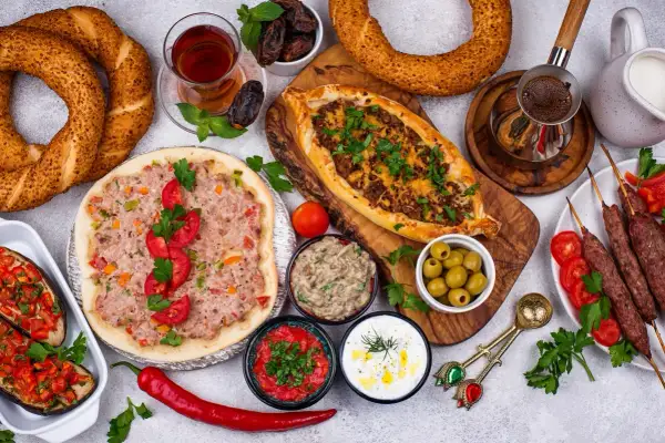 Pyszne albania jedzenie: pide, lahmacun, kebaby, bakłażany z warzywami, oliwki, dipy, chałka i herbata.