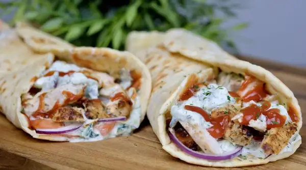 Dwa pyszne souvlaki w picie z kurczakiem, warzywami i sosem, gotowe do zjedzenia.