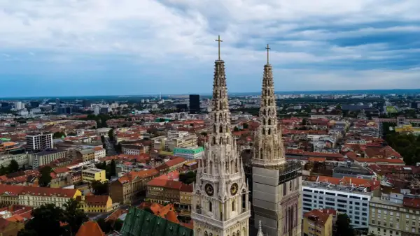 Dwie wieże katedry górują nad miastem. W oddali widać nowoczesne budynki i zielone tereny. To wspaniałe zagrzeb atrakcje.