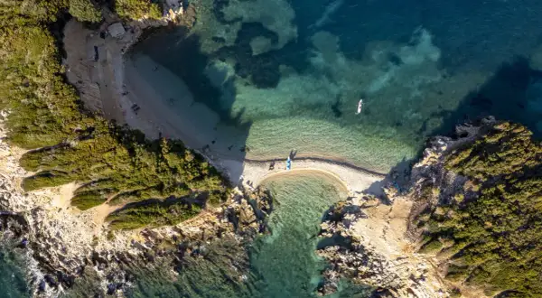 Albania, styczeń. Pogoda sprzyja wodnym aktywnościom na malowniczej plaży z turkusową wodą i kajakami.
