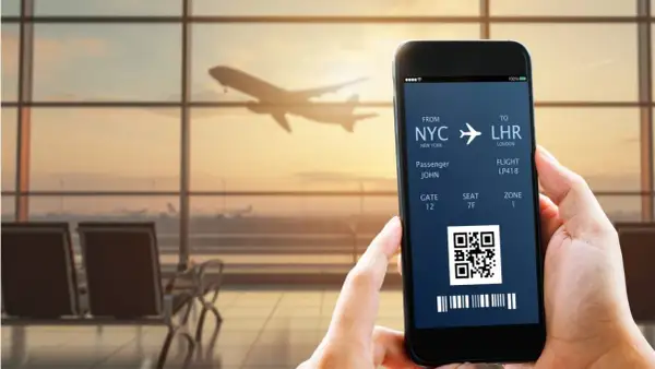 Bilet lotniczy na telefonie: NYC do LHR, pasażer John, lot LP418. IATA co to? To kod lotniska.