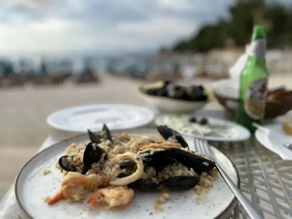Pyszne risotto z owocami morza i mule w jednej z saranda restauracji, z widokiem na plażę i morze.