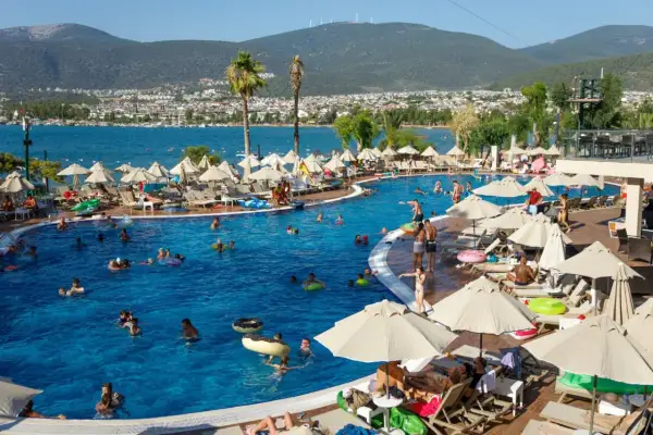Ludzie kąpią się w basenie hotelowym. Czy to all inclusive, czy ultra all inclusive? Różnica tkwi w szczegółach!